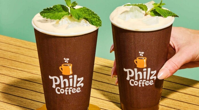 Two iced coffee drinks in brown Philz Coffee cups with mint garnish on a wooden table.