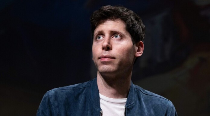 Anti-Ai Activist Charged In Firebomb Attack Targeting Openai CEO Sam Altman’s Home Young man with short dark hair wearing a blue jacket and white shirt looks upward against a dark background.