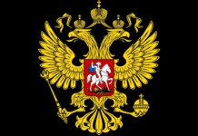 Gold double-headed eagle with crowns, scepter, and orb on a black field, bearing a red shield with a mounted knight (Russian coat of arms).