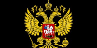 Gold double-headed eagle with crowns, scepter, and orb on a black field, bearing a red shield with a mounted knight (Russian coat of arms).