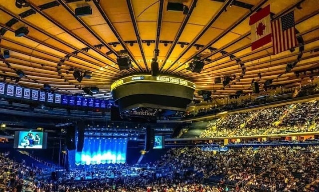 A Trans Woman of Zero Threat Was Allegedly Tracked for Years by Madison Square Garden Security Large indoor arena full of seated attendees watching a blue-lit stage perform.
