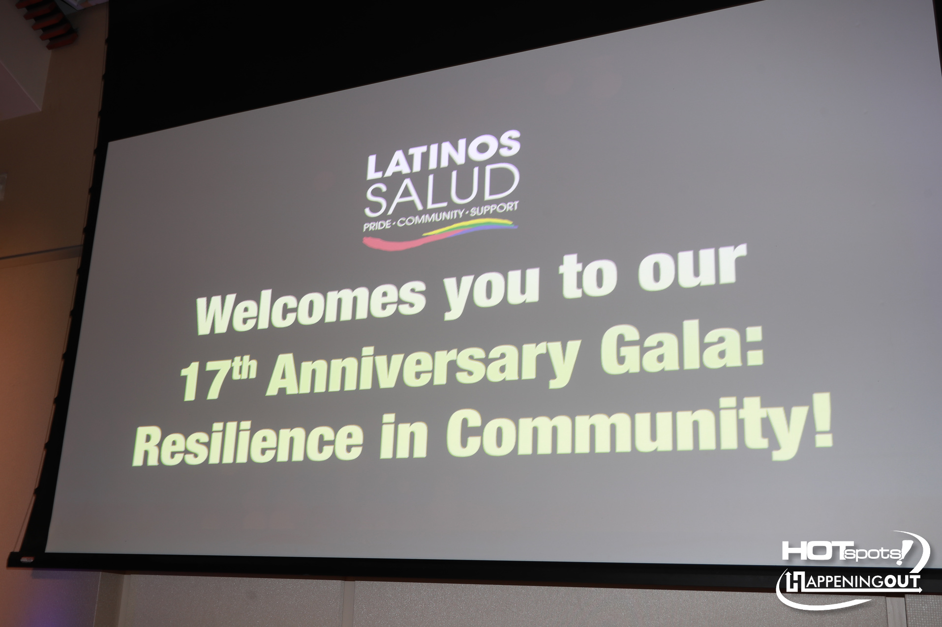 Slide with Latinos Salud logo and a welcome message for the 17th Anniversary Gala; logos for HOTspots and HappeningOut visible bottom-right.