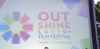Group of eight people posing on a stage in front of a colorful Out Shine LGBTQ+ Film Festival banner reading Miami & Fort Lauderdale.