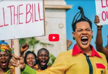 Protesters hold signs reading 'KILL THE BILL' as a woman in yellow shouts energetically at a rally.