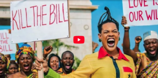 Protesters hold signs reading 'KILL THE BILL' as a woman in yellow shouts energetically at a rally.