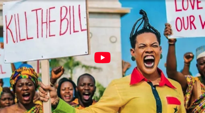 Protesters hold signs reading 'KILL THE BILL' as a woman in yellow shouts energetically at a rally.