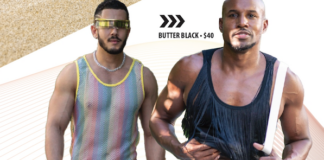 Two muscular men in retro mesh tops and briefs pose for a Butter Black ad, walking toward the camera with confident stances.