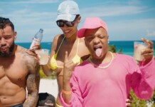 Three friends at the beach pose and sip drinks, with the ocean in the background and bright sunny weather时 (informative)