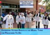 Diverse group of people outside a polling place holding signs encouraging voting and democracy.