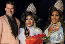 Three drag performers pose on stage; center winner in a silver gown and crown holds a red rose bouquet, flanked by two smiling contestants.
