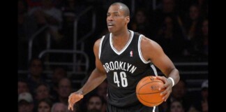 Basketball player in a Brooklyn Nets jersey with number 46, dribbling a ball during a game.