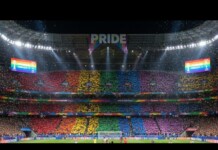 Fans in a stadium hold rainbow cards, creating a Pride banner across the stands beneath a large 'PRIDE' sign.