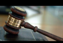 China Supreme Court Acknowledges LGBTQ Discrimination in Rare Public Statement Wooden judge's gavel with a brass band reading 'People's Court' resting on a desk in a courtroom setting.