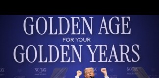 Speaker at a podium during a political rally; the blue backdrop displays the large slogan 'GOLDEN AGE FOR YOUR GOLDEN YEARS' and 'NO TAX' banners nearby, with the speaker raising his fists in the air.