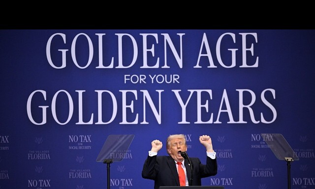 Trump Targets Trans People During Meandering Speech at Florida’s LGBTQ Friendly The Villages Speaker at a podium during a political rally; the blue backdrop displays the large slogan 'GOLDEN AGE FOR YOUR GOLDEN YEARS' and 'NO TAX' banners nearby, with the speaker raising his fists in the air.