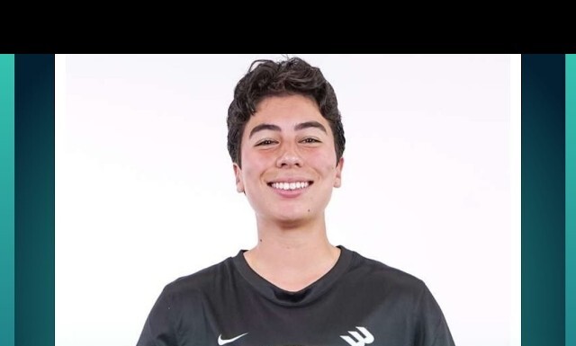 Minnesota Aurora FC Signs First Out Transgender Player Isaac Ranson to Women’s Team Smiling young person in a dark jersey holding a soccer ball against a white studio background.
