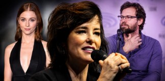 Deep Inside Hollywood: Audrey Hepburn Biopic, ‘Las Malas,’ Parker Posey, Nick Jonas & More Entertainment News Female singer in front holding a microphone, flanked by a red-haired woman in black on the left and a bearded man with glasses on the right at a panel event.