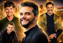 Group portrait of four men smiling against a golden Hollywood skyline and film reels backdrop, like a movie poster.