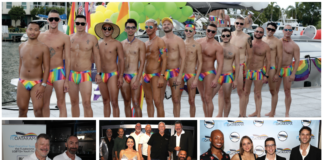 Group of men in rainbow-striped swimsuits posing shirtless on a dock with a boat and yellow-green balloons in the background
