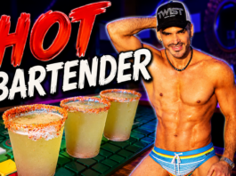 HOT Bartender – Jaime Erben Muscular, shirtless bartender wearing a cap stands beside three salted margaritas on a neon-lit bar.