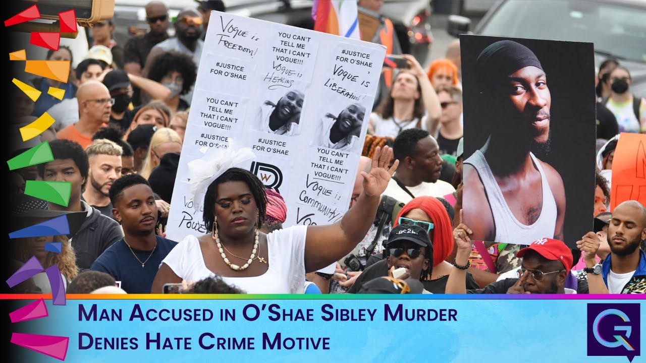 Crowd of diverse protesters holding signs and a large portrait photo, with a blue news banner at the bottom reading a hate-crime murder story.