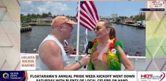 Reporter interviews a Pride event participant on a boat with an American flag in the background at Greater Wilton Manors parade stop.