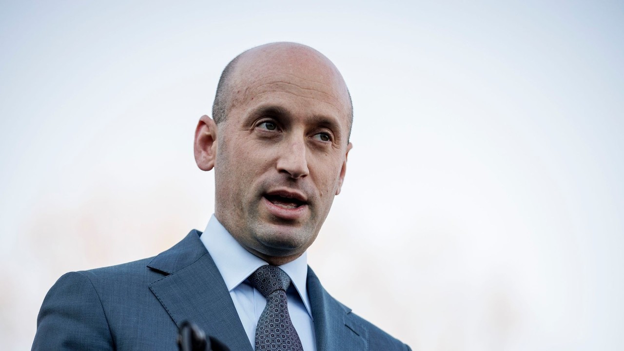White House Official Faces Backlash Over Gender-Based Attacks on Texas Democrat James Talarico Bald man in a blue suit and patterned tie speaking outdoors, looking to the side.