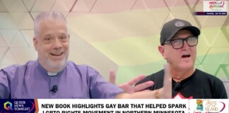 Two men host a TV segment in a colorful studio; a bold caption banner reads 'NEW BOOK HIGHLIGHTS GAY BAR THAT HELPED SPARK LGBTQ RIGHTS MOVEMENT IN NORTHERN MINNESOTA' with logos on the sides