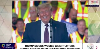 Donald Trump at a microphone, smiling, speaking to a crowd of workers in high‑visibility vests; on-screen headline reads 'TRUMP MOCKS WOMEN WEIGHTLIFTERS DURING SPEECH TO MANUFACTURING WORKERS'