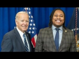 Biden Honored for LGBTQ+ Advocacy at Philadelphia Stonewall Awards During Pride Month Two men in suits posing for a photo in front of American flags, smiling at the camera.