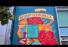 Colorful mural on a building advocating for decriminalization of sex work in California, with raised fists and flowers.