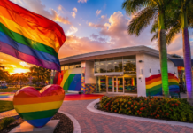 Non-Profit Advocacy: The Pride Center at Equality Park Rainbow flag waves above a rainbow-painted plaza in front of a modern building at sunset for a Pride-themed scene.