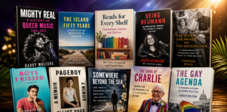 Row of colorful book covers about LGBTQ+ history on a wooden shelf, foregrounded with bold titles and photos in a studio setting.