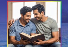 Two men sit closely together, smiling, as they read a book aloud to each other indoors.