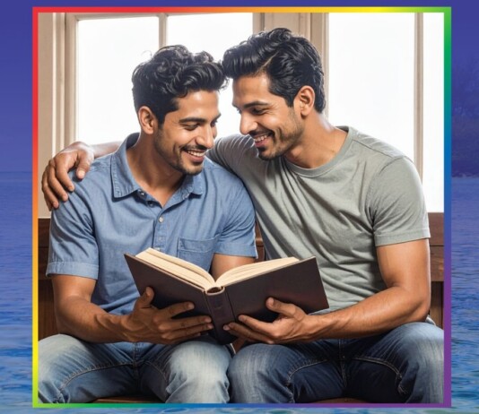Two men sit closely together, smiling, as they read a book aloud to each other indoors.