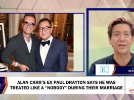 Alan Carr’s Ex Paul Drayton Says He Was Treated Like a “Nobody” During Their Marriage Two men in suits pose together at an awards event on a blue-framed split-screen, with a TV news anchor on the right set.