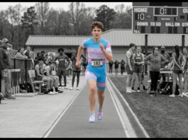 US Supreme Court Upholds State Bans on Transgender Girls Competing in Girls’ Sports Runner in a blue-pink uniform sprinting on a track with bib 102, as spectators watch from the sidelines.