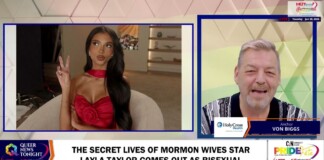 Split-screen TV interview: woman in red dress on left making a peace sign; host on right with 'Von Biggs' banner and a news headline about Layla Taylor coming out as bisexual.