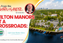 From The Publisher: Wilton Manors At a Crossroads – Investing in The Community We Love Promotional banner: Wilton Manors at a Crossroads with a portrait, city skyline, and waterway image; bold red title and crest logos.