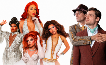 Group portrait of five drag queens in glamorous gowns and makeup posing next to two men in retro suits on a white background.