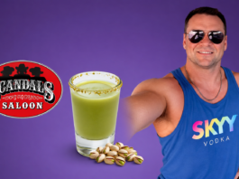 Hot Bartender – Joe Payne Man in sunglasses and a blue SKYY Vodka tank top poses with a green salted-rim drink and pistachios beside a Scandal's Saloon logo on a purple background.