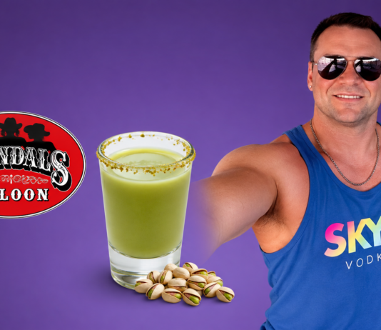 Man in sunglasses and a blue SKYY Vodka tank top poses with a green salted-rim drink and pistachios beside a Scandal's Saloon logo on a purple background.