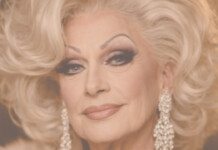 Close-up portrait of a glamorous older woman with platinum blonde hair and diamond earrings.