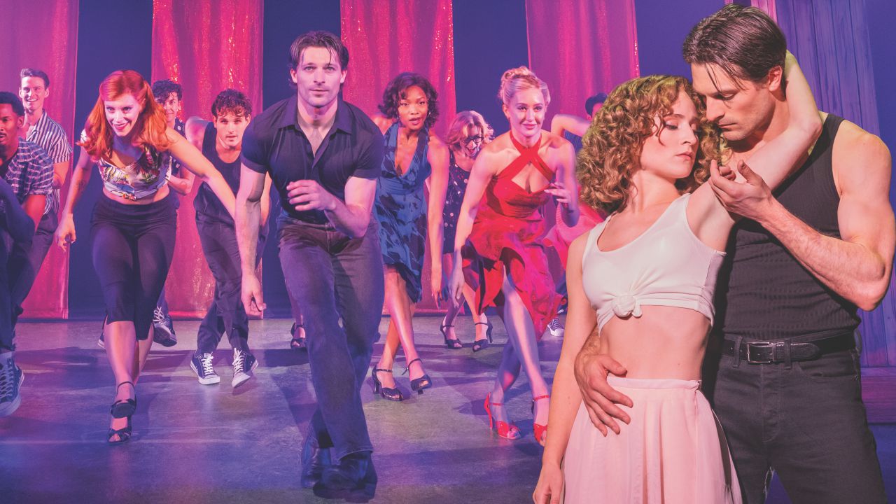 Couple dancing closely in foreground on a stage with a group dancing behind them under pink stage lighting.