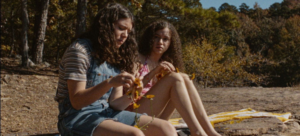 Outshine Film Festival’s Fall Edition – Fort Lauderdale and Miami from Oct 15-25 | Hotspots Magazine Hotspots Magazine Two young women sit on a blanket in a wooded area, weaving yellow flowers into garlands.
